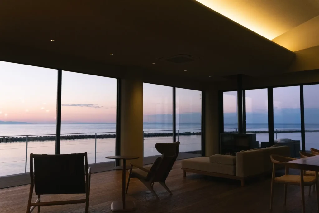 夕暮れ時のリビングルーム。一面ガラス張りでまるで海とひとつのような感覚